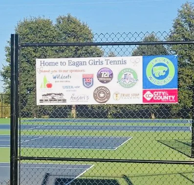 Eagan Girls Tennis courts with a banner thanking local sponsors